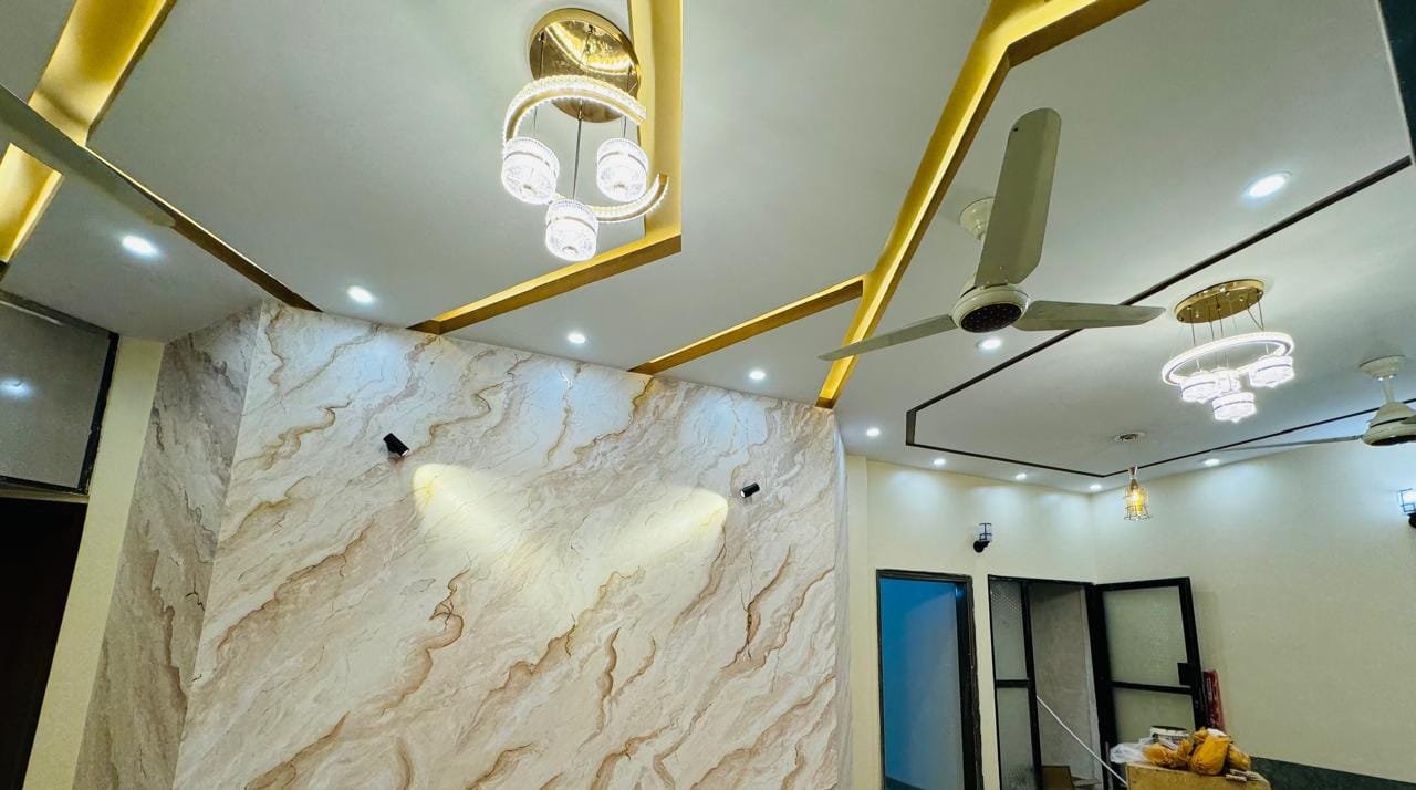 Modern false ceiling design with gold cove lighting and chandelier by Nazar Ceiling Design
